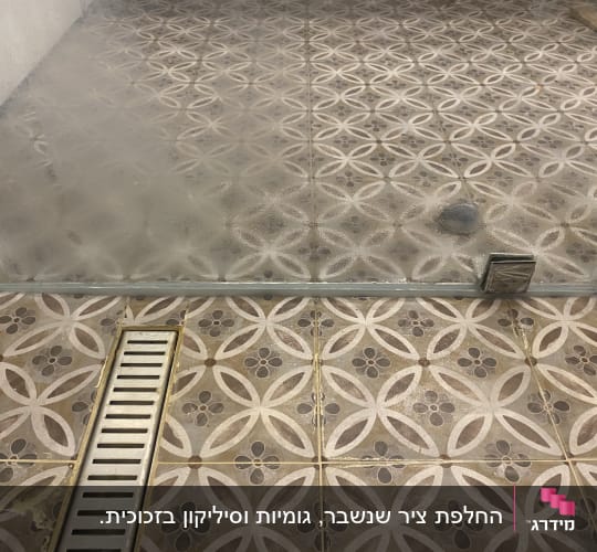 רצפת מקלחת עם אריחים ודלת זכוכית